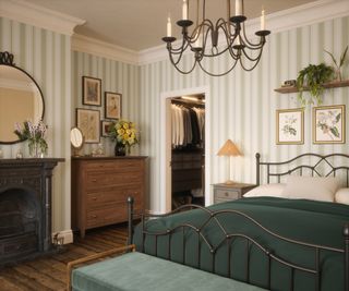 bedroom with fireplace, striped wallpaper, large bed and opening into dressing room