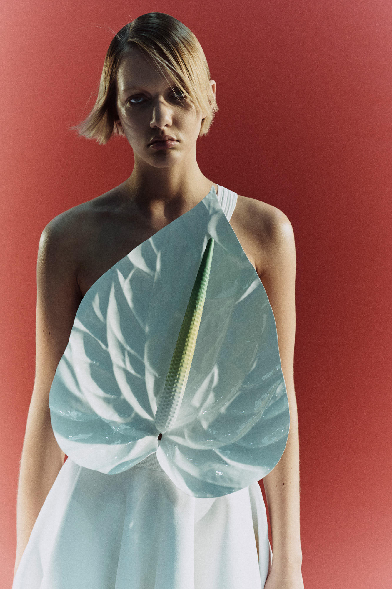 Woman with giant anthurium flower on front of dress by Loewe
