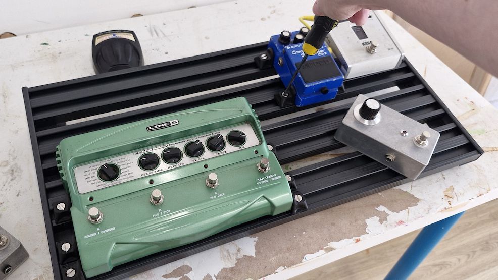 An Aclam Smart Track S2 pedalboard with some pedals attached