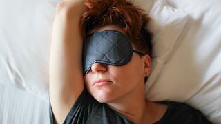 woman lying in bed wearing eye mask