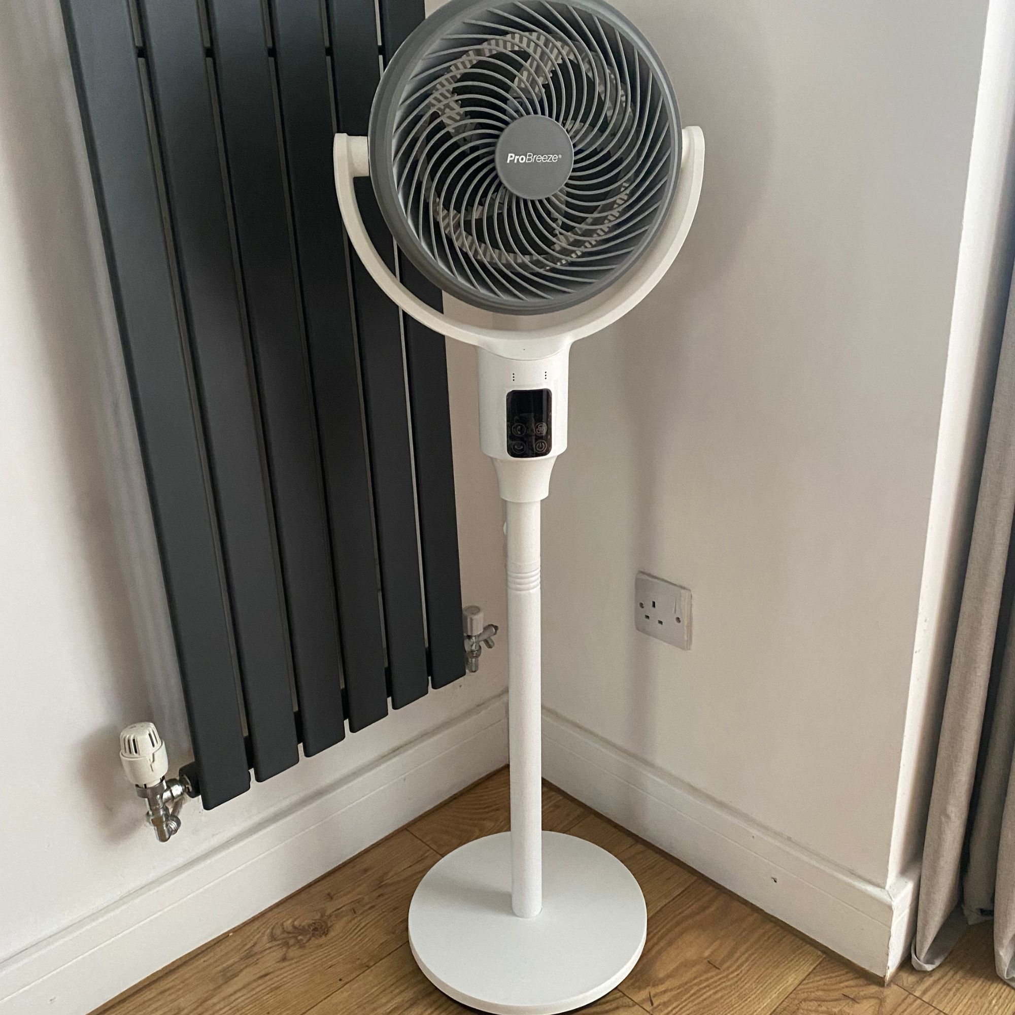 Pro Breeze Airflo 43'' Hybrid Pedestal Fan in pedestal configuration next to a vertical radiator