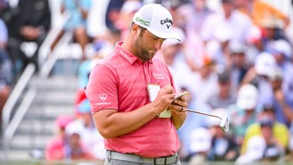 jon rahm marking a scorecard