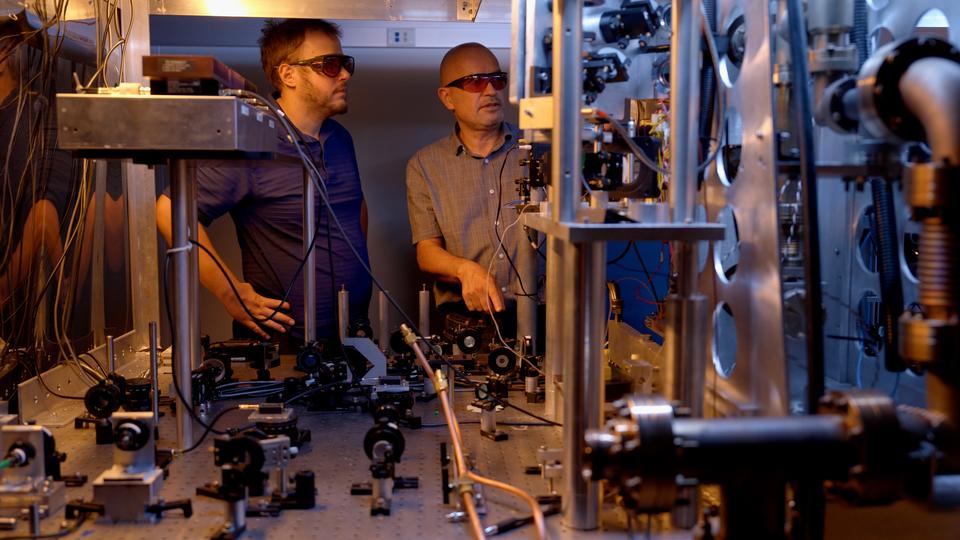 Two researchers work on an atomic clock
