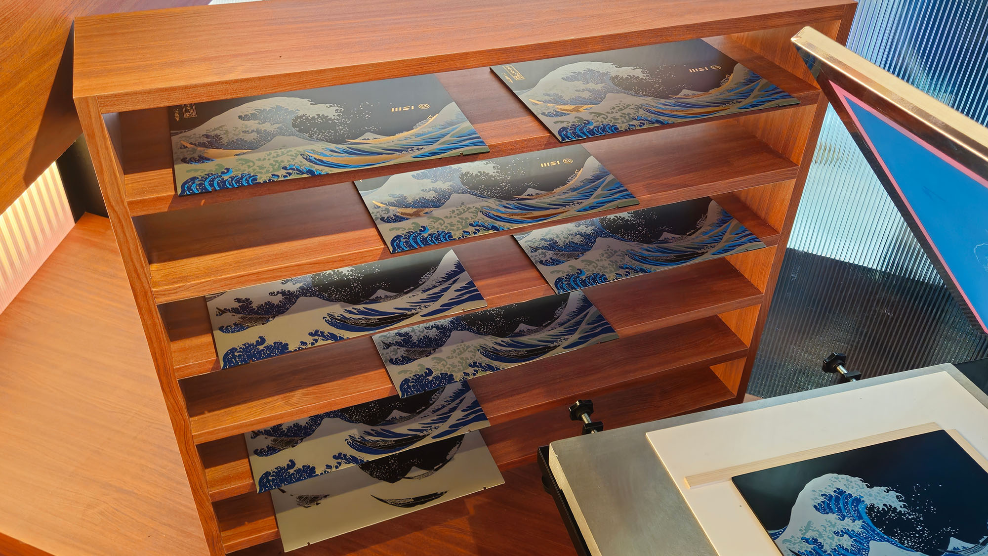 A shelf containing several in progress lids on the MSI Prestige 13+ AI Ukiyo-e Edition laptop showing the different steps in the lacquer process