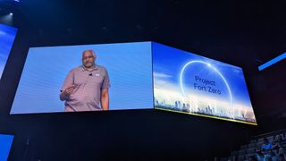 A large screen showing Herb Kelsey, industry CTO - government at Dell, with another screen on the right with the words 'Project Fort Zero' against a background of a skyline with a glowing arc overhead.