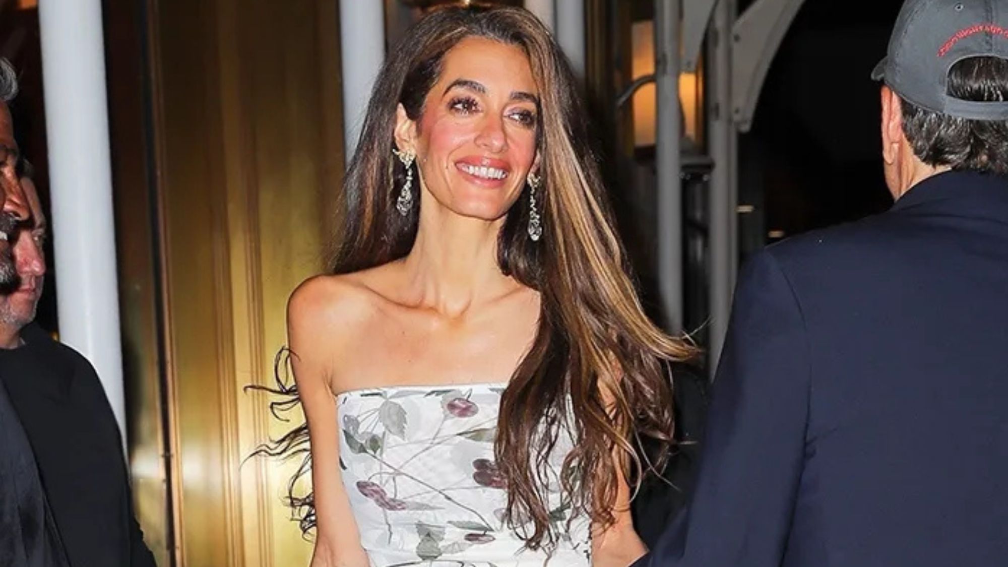 Amal Clooney wearing statement earrings and a white strapless dress in NYC with George Clooney