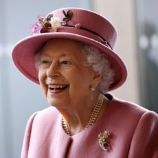 Queen Elizabeth II laughs in a pink suit and matching hat