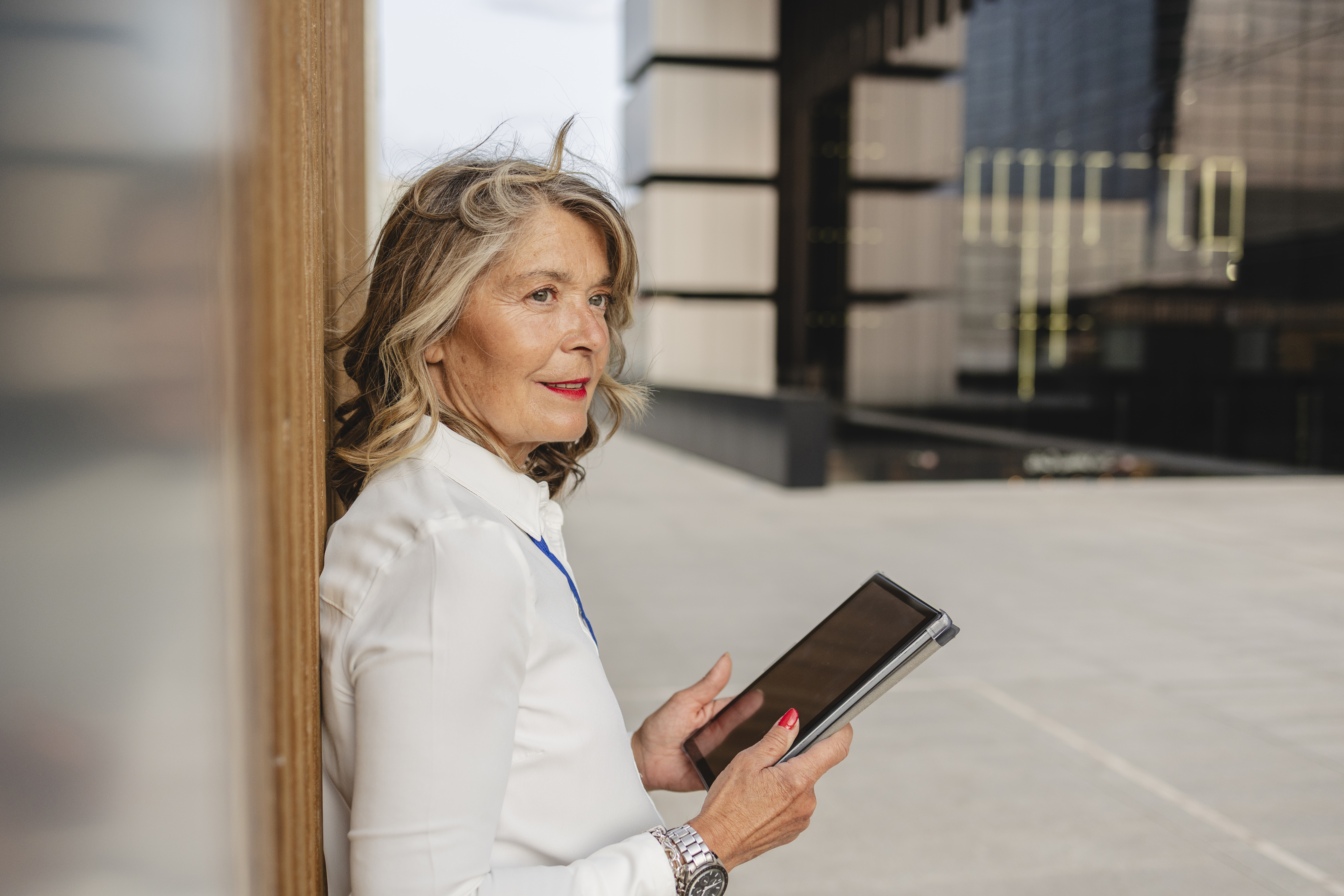 Confident professional with tablet outdoors in modern urban setting