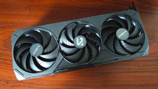 Gigabyte RTX 5070 Ti graphics card lying flat on woodgrain desk