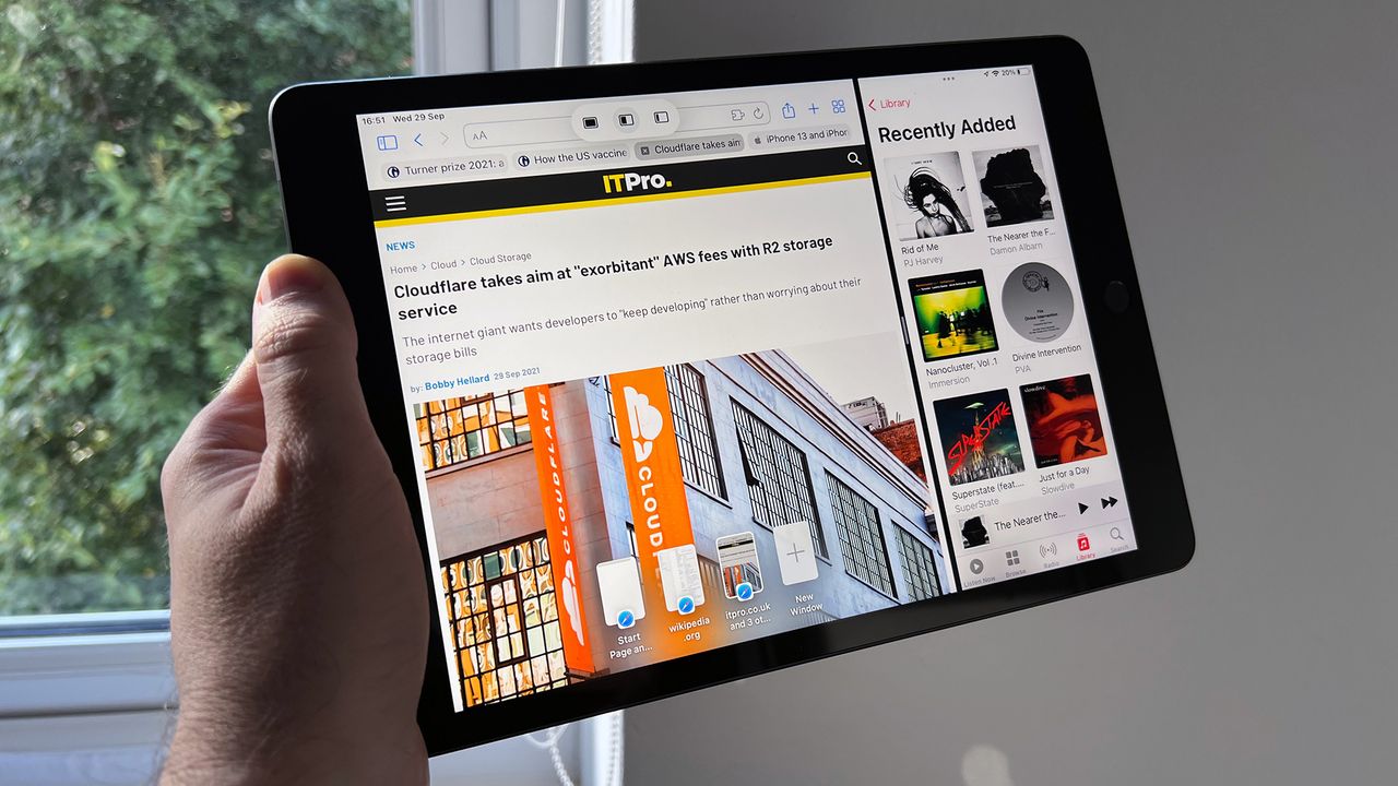 A photograph of the 12.9in 2021 Apple iPad Pro held up in front of a window