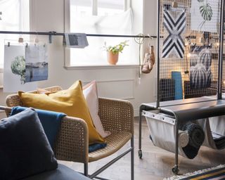 A living room with home gym setup with curtain rail used as a barre or ballet rail and mesh divider