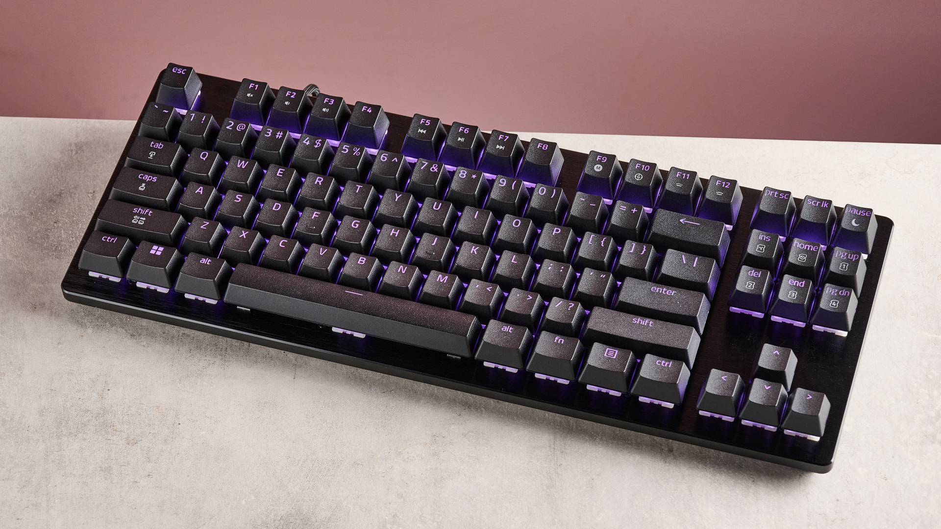 three-quarter view of Razer Huntsman V3 HE Magnetic Tenkeyless 8KHz on desk with pink wall in background
