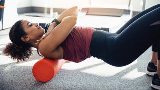 Woman using a foam roller on her back