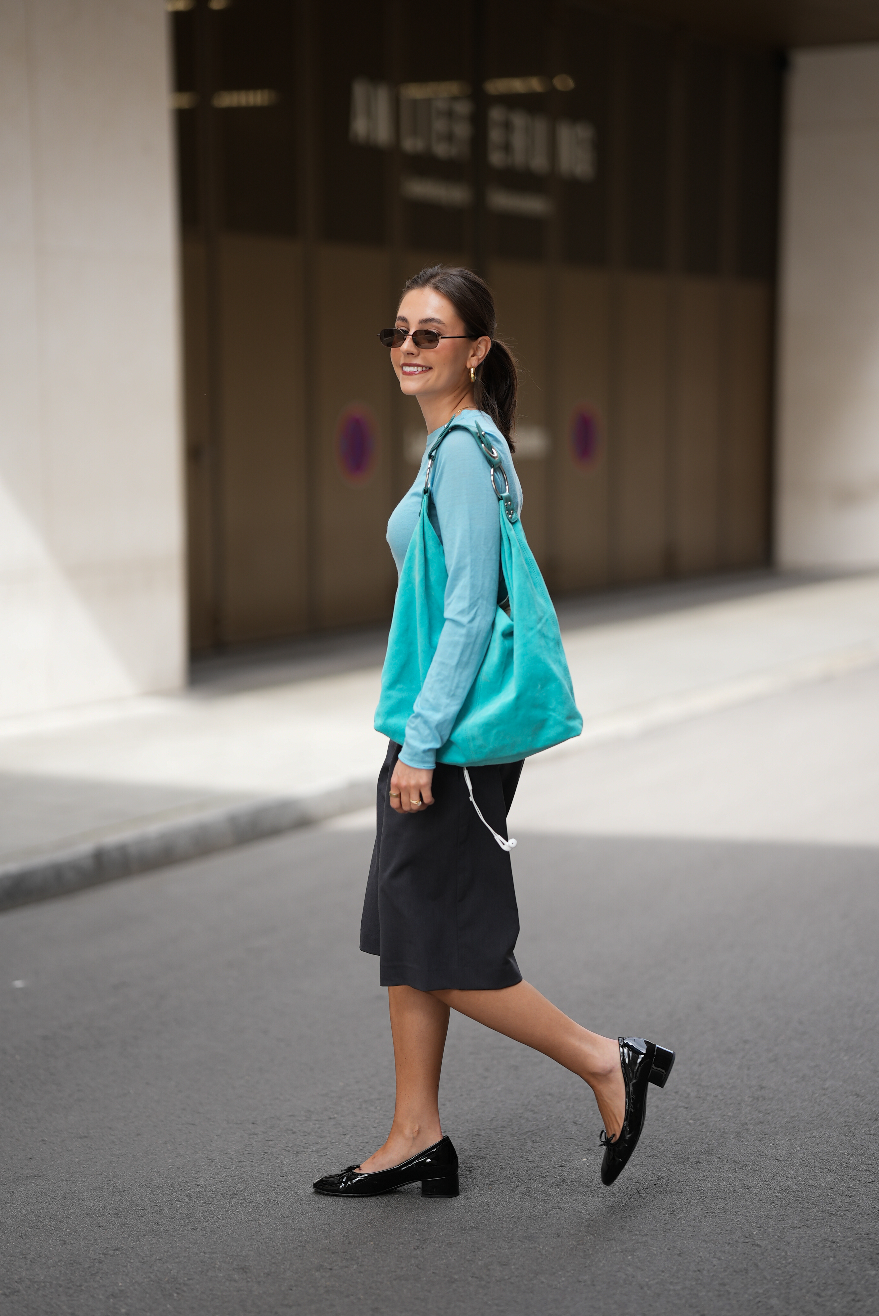woman wearing aqua top, black pants, and black shoes