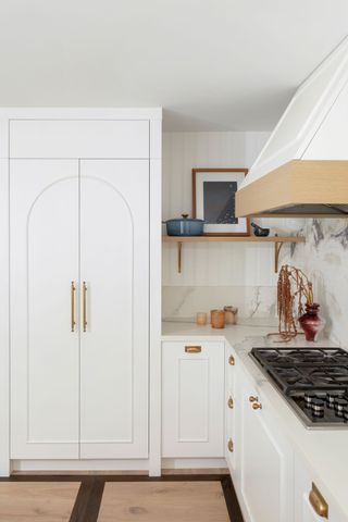 a white kitchen with an arched door design