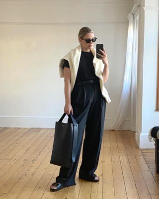 British fashion influencer Alexis Foreman standing in a spring outfit with black trousers