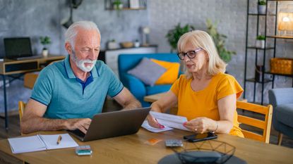 A senior couple pays the bills.