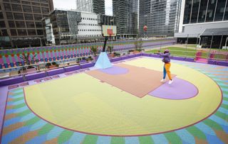 Yinka Ilori playing basket in his colourful court in Canary wharf, London