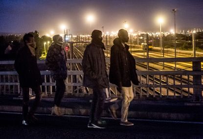 Migrants try to jump trains to Britain from Calais, France