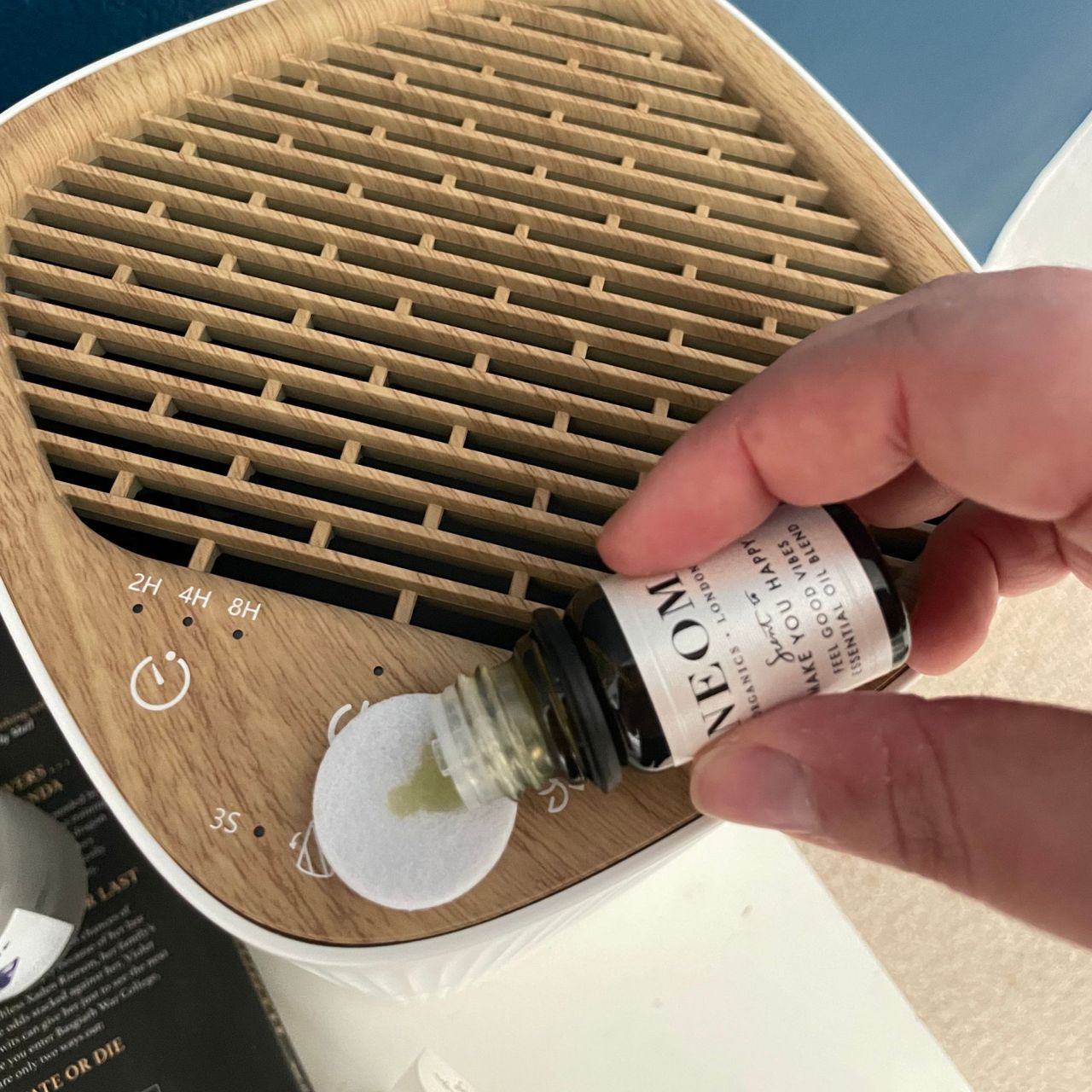 Pouring essential oil onto the fragrance pad of the Russell Hobbs bedroom air purifier
