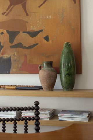 a close up of floating shelves with magazines and vases on