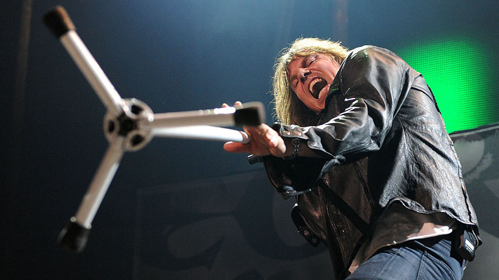 Action stage shot of Joey Tempest attacking a photographer with a mic stand