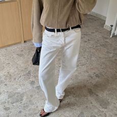 A woman taking a mirror selfie wearing heels with a black pedicure