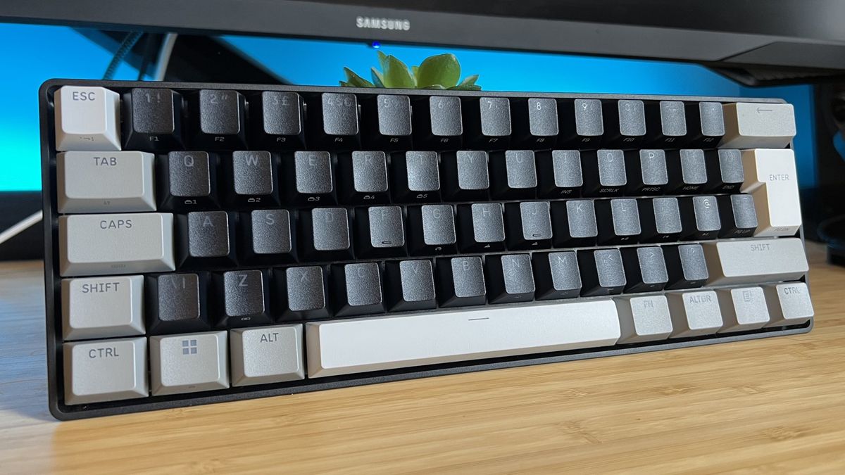 Corsair Clipper Pro Mini 60 keyboard on a wooden desk with blue backlighting
