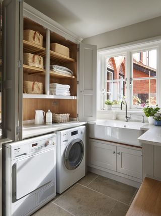 how to organize a laundry room with wall cabinet and storage baskets by Martin Moore