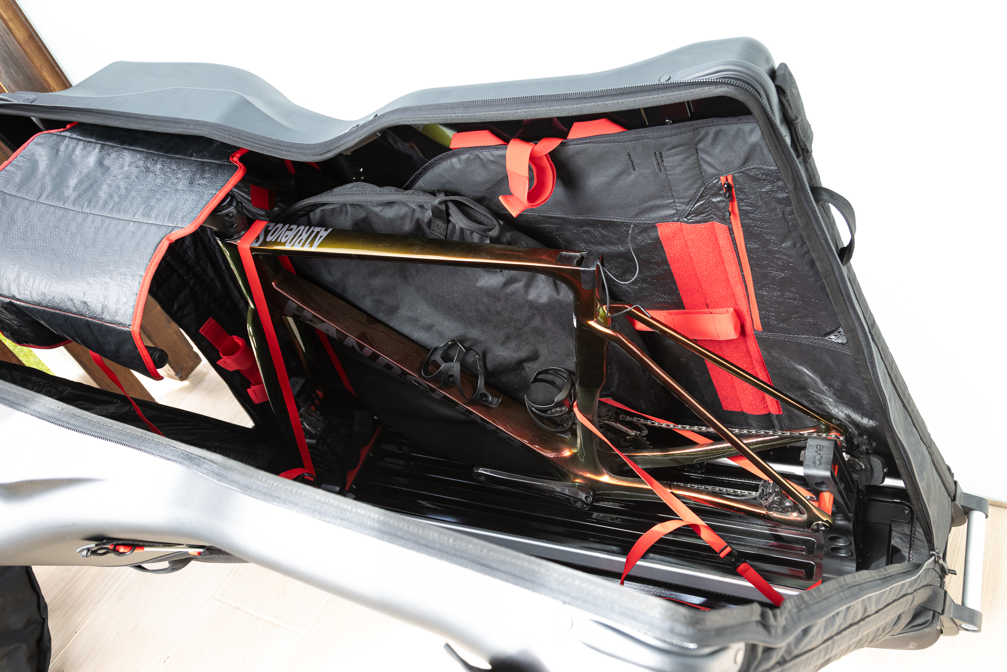 An orange bike frame sitting in a black bike bag