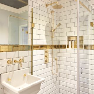 bathroom with white tiles and golden fixtures