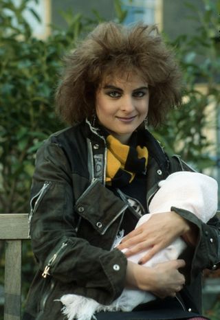 Mary 'The Punk' Smith holding her baby Annie in a white blanket.