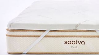 Saatva graphite topper secured via thick elasticated bands to a Saatva luxury mattress
