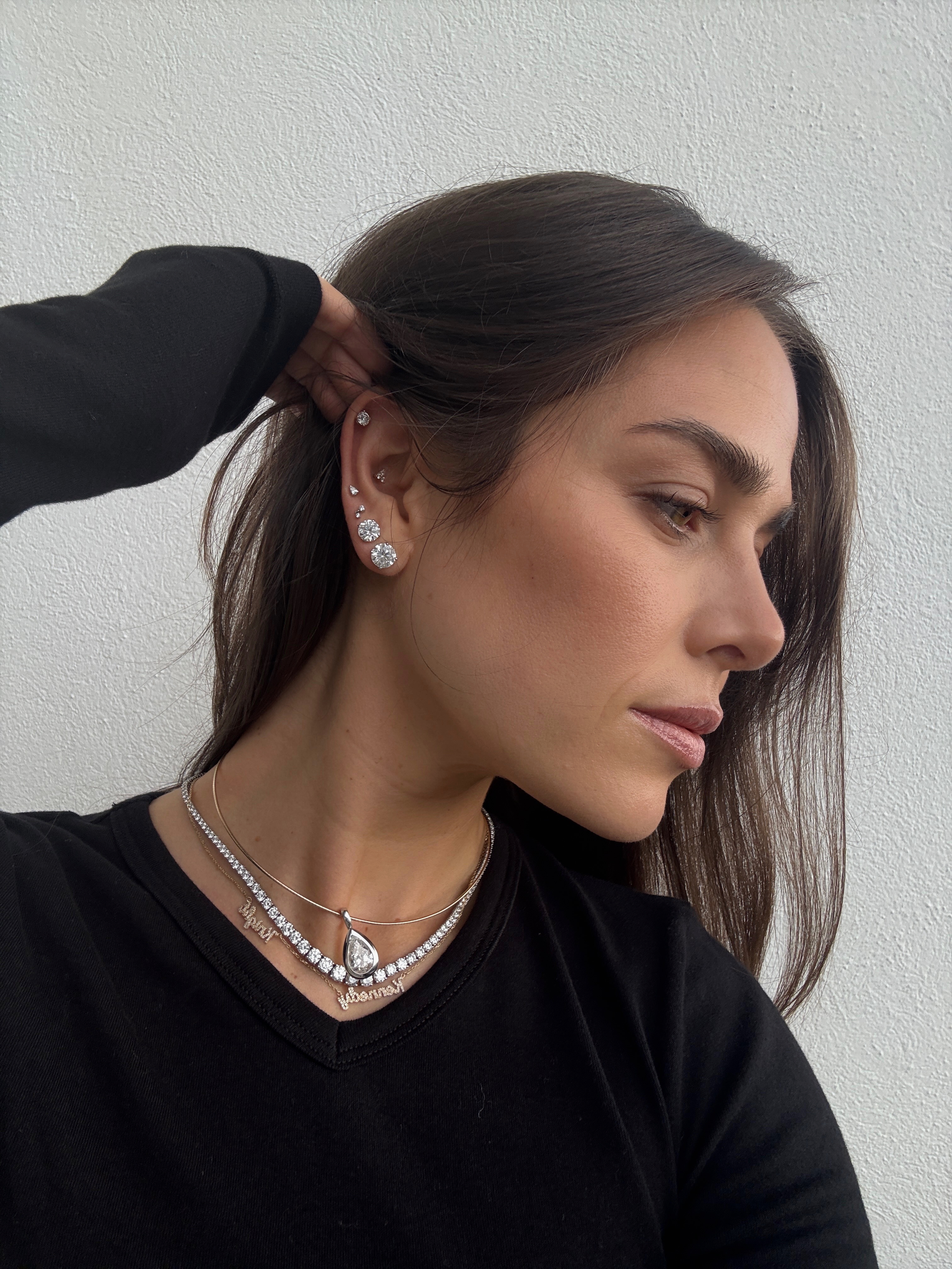Kira Mackenzie Jackson wears a stack of diamond earrings with three diamond necklaces