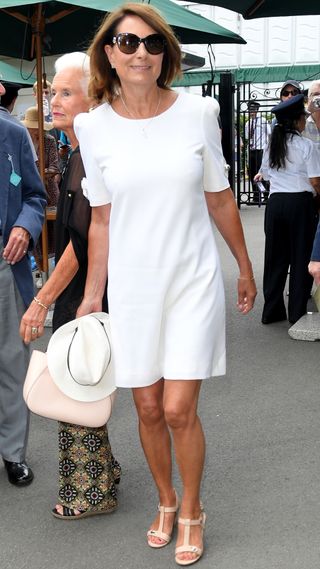 Carole Middleton attends day 3 of the Wimbledon Tennis Championships in 2019 wearing a white dress and pink-beige sandals