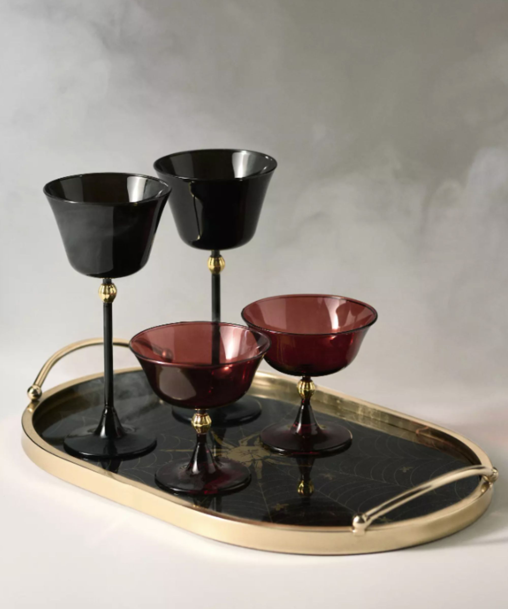 Black and red glasses on a black and gold tray