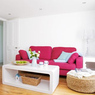 white living room with pink sofa and wooden floor
