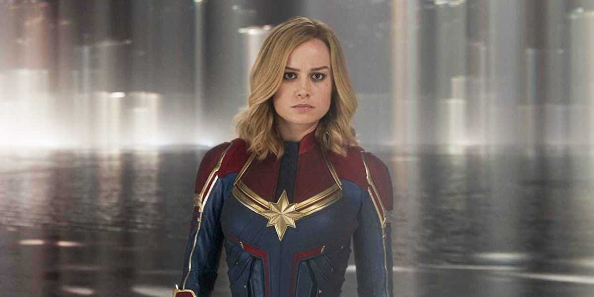 Carol Danvers (Brie Larson) stans wearing her Captain Marvel costume.