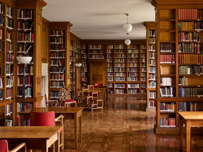 Fig 3: The library was well planned, with short shelves to prevent sagging. The spider-back chairs were a favourite Lutyens design. Campion Hall, University of Oxford. Photographed by Will Pryce for the Country Life Picture Library. &copy;Country Life