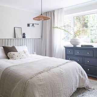 Neutral bedroom colour scheme with double bed, chest of drawers, and rug underneath bed