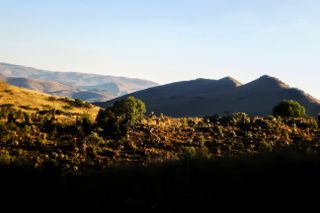 low hills and mountains during sunset