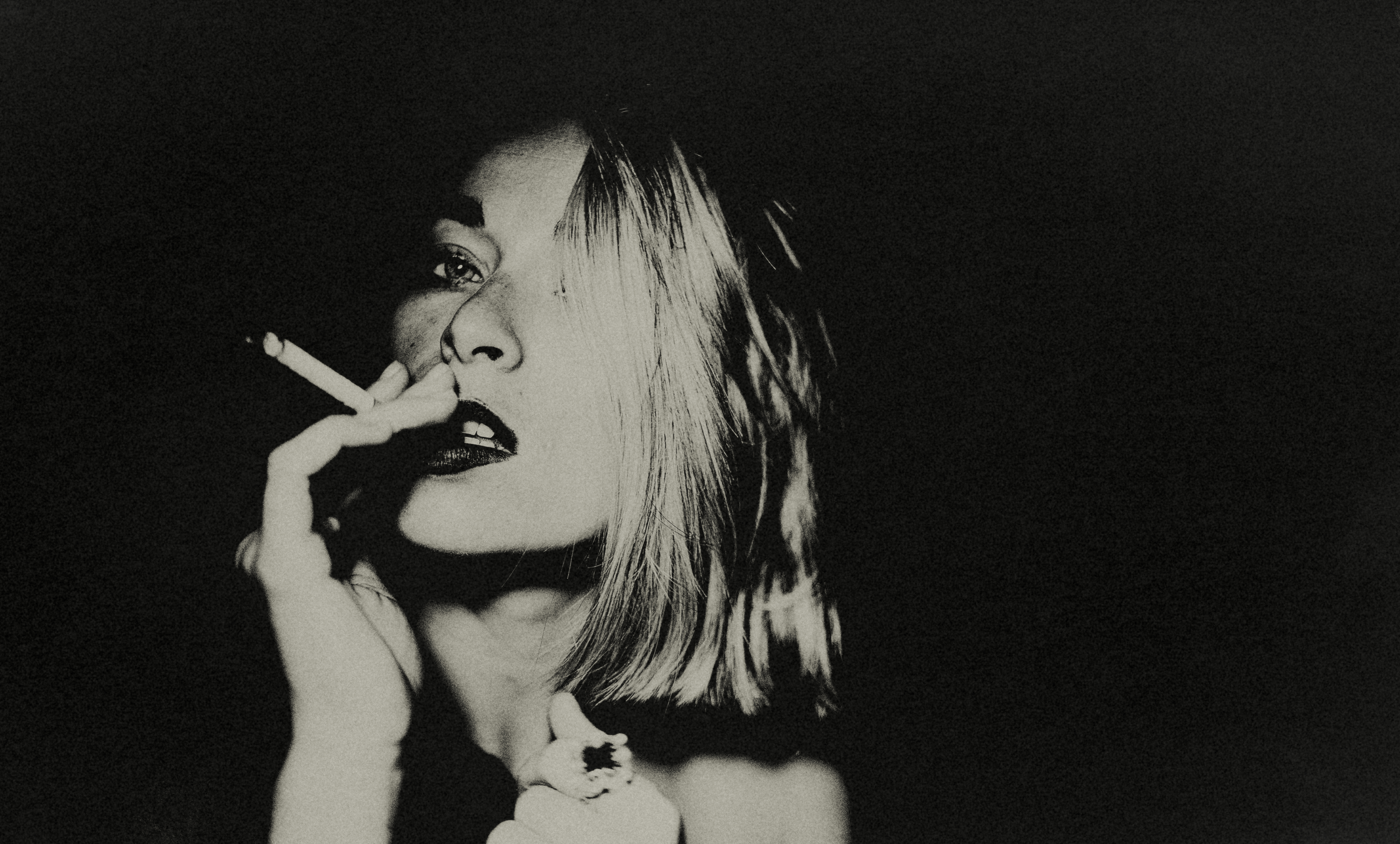 Young woman with short blonde hair smoking