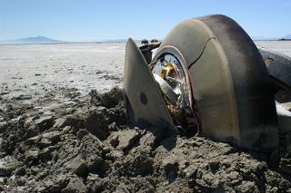 a smashed cone-shaped capsule on the desert floor