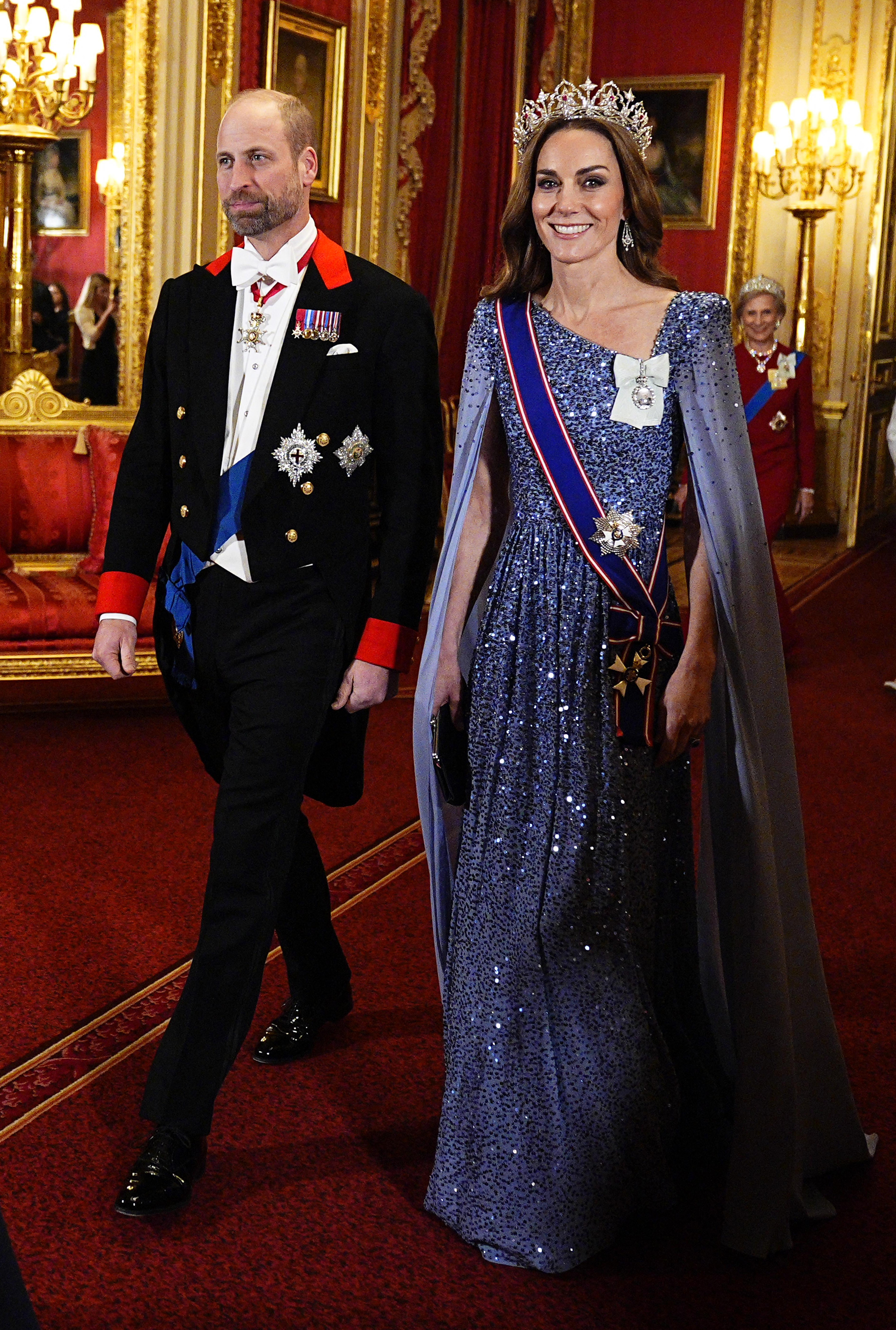 Princess Kate wearing a blue dress and tiara walking next to Prince William