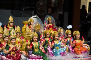 Street vendors sell colorful clay idols of the goddess Lakshmi for Diwali.