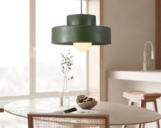 Green pendant light above dining table