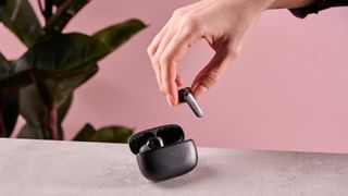 Person picking up Earfun Air 2 NC bud out of charging case