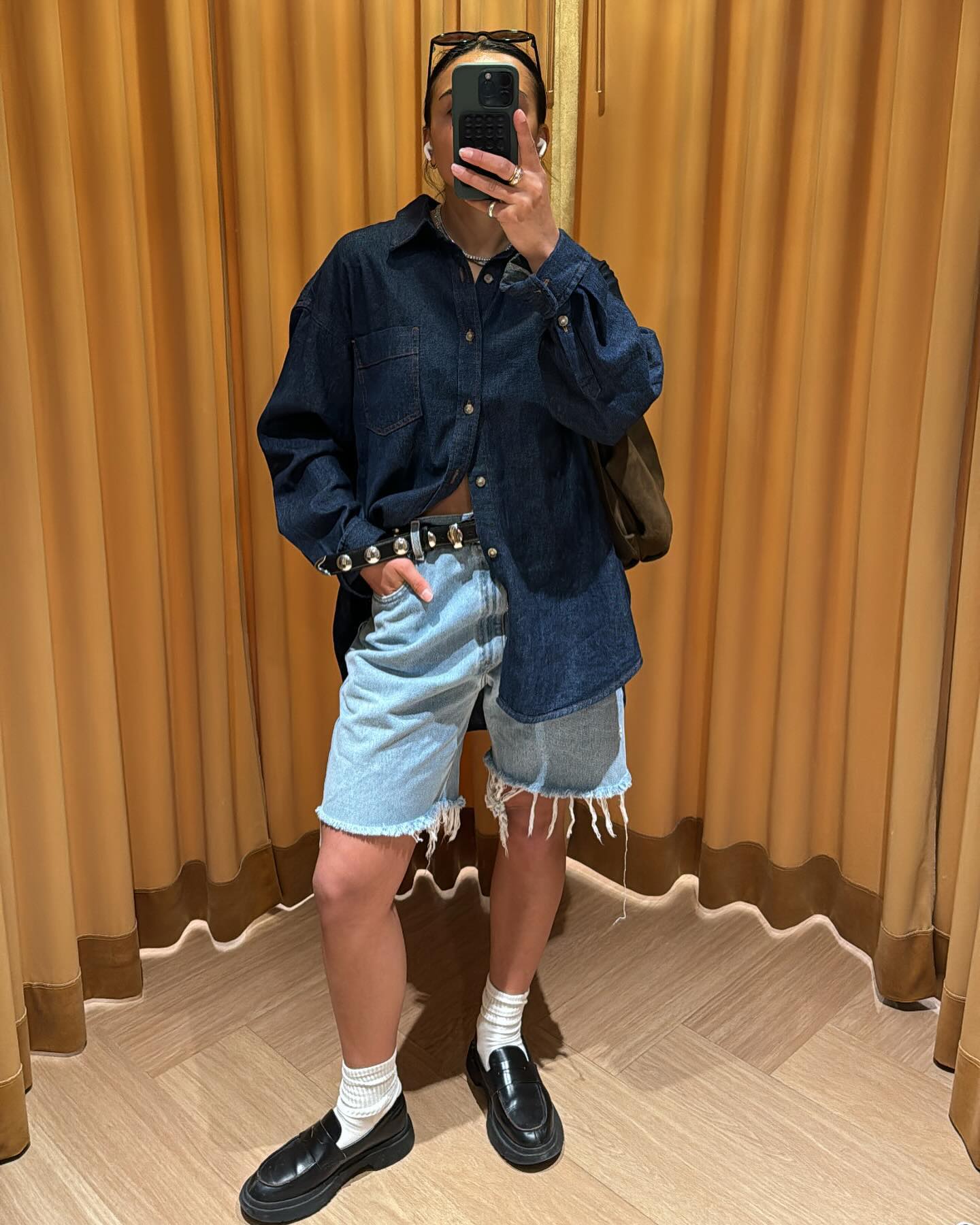 @chloemihailo wears a pair of blue denim Bermuda shorts with black loafers