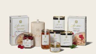 Boxes and jars of Meghan Markle's As Ever products such as jam and cookie mix sitting on a cream background