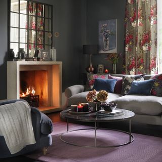 living area with grey wall and fireplace and grey sofa and cushions